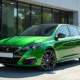 Peugeot 308 GT neuve devant un bâtiment moderne ensoleillé
